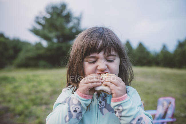Молода дівчина, на відкритому повітрі, їсть s'more, крупним планом — стокове фото