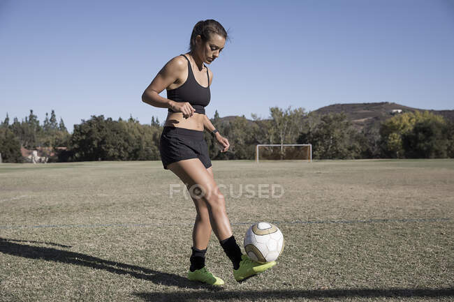 Femme sur le terrain de football jouant au football — Photo de stock