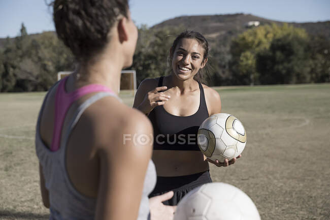 Women on football pitch with football chatting — Stock Photo