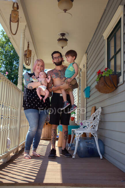 Família na varanda da frente da casa — Fotografia de Stock