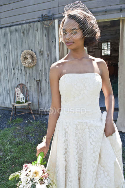 Portrait of bride in wedding dress with bouquet — Stock Photo