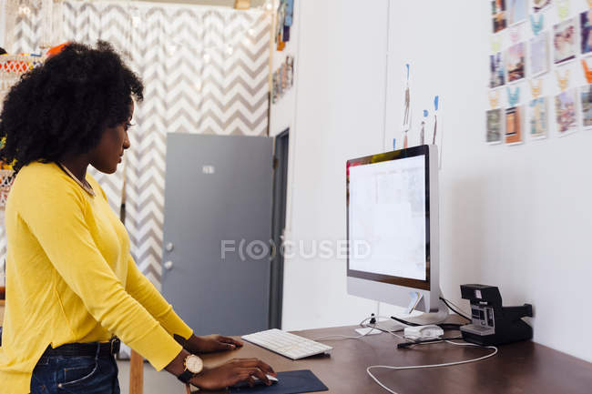 Vista laterale della donna in studio creativo utilizzando il computer — Foto stock
