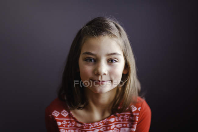 Retrato de una chica sonriente mirando a la cámara - foto de stock