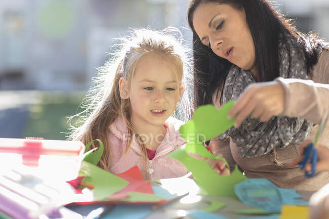 Mid adult woman helping young girl with crafting activity — Stock Photo
