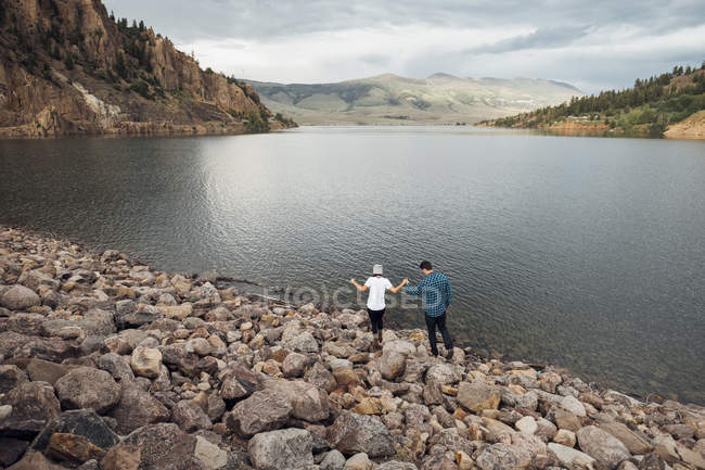 Coppia camminando su rocce accanto a Dillon Reservoir, vista elevata, Silverthorne, Colorado, Stati Uniti d'America — Foto stock
