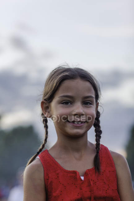 Portrait de fille souriante avec deux nattes à l'extérieur — Photo de stock
