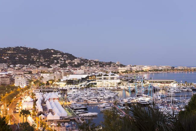 Cityscape with waterfront hotels and marina at dusk, Cannes, Cote d'Azur, France — Stock Photo