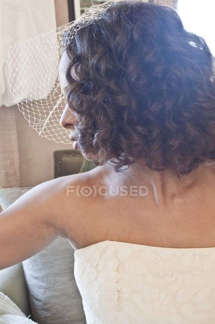 Портрет невесты в свадебном платье и вуали, смотрящей в сторону — стоковое фото