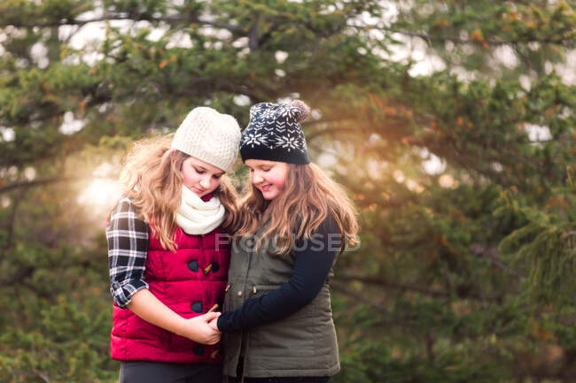 Girl and her sister holding hands and looking down in garden — Stock Photo