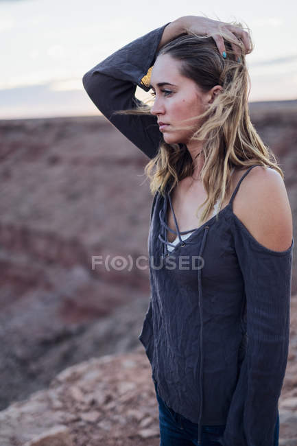 Jovem mulher olhando para a vista e segurando o cabelo fora do rosto, Chapéu Mexicano, Utah, EUA — Fotografia de Stock