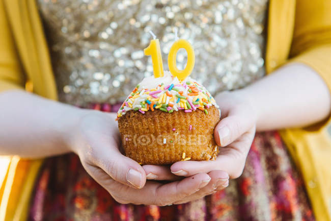 Young woman holding cupcake celebrating — Stock Photo