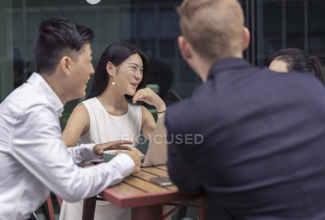 Коллеги сидят вместе в кафе на открытом воздухе — стоковое фото