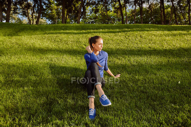 Femme assise sur l'herbe regardant loin, Odessa, oblast d'Odeska, Ukraine, Europe — Photo de stock