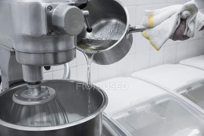 Koch gießt Flüssigkeit aus Topf in Mixer — Stockfoto