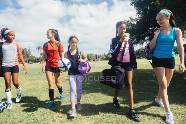 Alunas caminhando para a prática de futebol no campo esportivo escolar — Fotografia de Stock