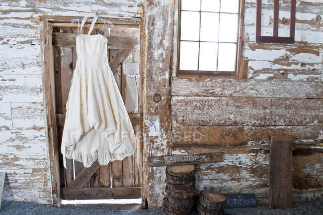 Vestido de novia vintage colgando en la puerta del granero - foto de stock
