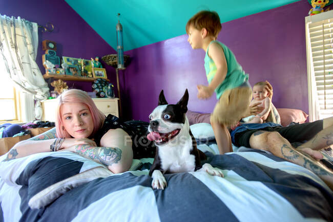 Семья и собака на кровати в спальне — стоковое фото