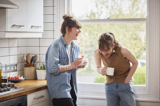 Friends chatting in kitchen — Stock Photo