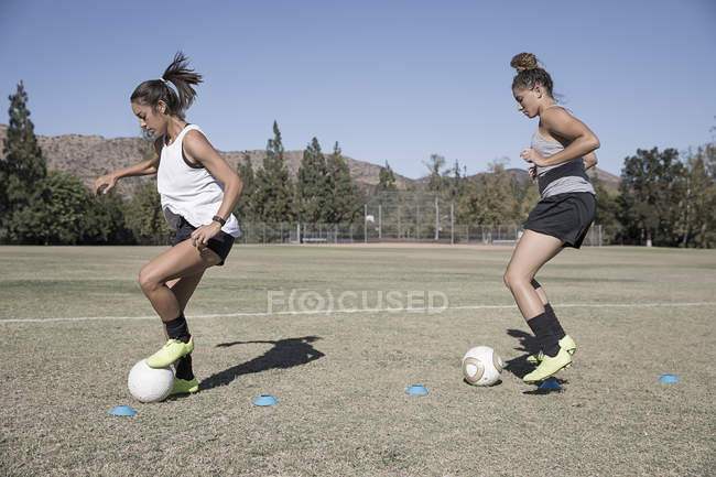 Vue latérale des femmes dribble footballs — Photo de stock