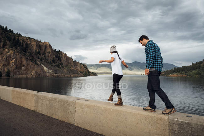 Couple walking along wall beside Dillon Reservoir, Silverthorne, Colorado, USA — Stock Photo