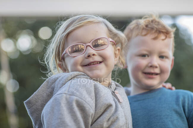 Девочка и мальчик в детском саду, портрет в саду — стоковое фото