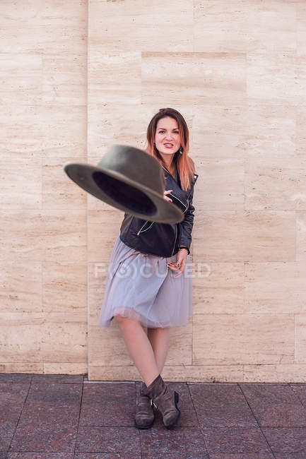 Porträt einer Frau in Lederjacke, die Hut wirft — Stockfoto