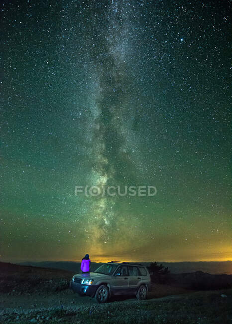 Человек, сидящий на машине, глядя на вид на Млечный путь, вид сзади, Провинциальный парк Никелевой плиты, Пентиктон, Британская Колумбия, Канада — стоковое фото