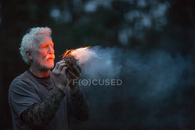 Hombre encendiendo fuego - foto de stock