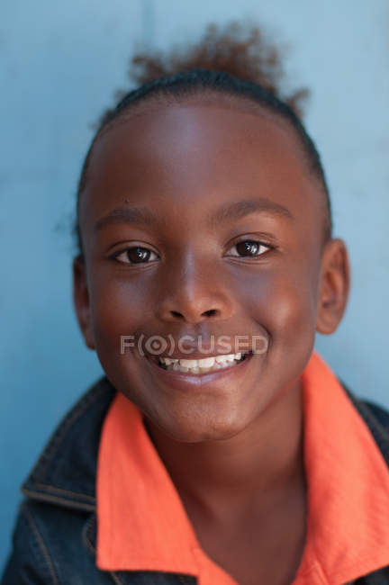 Портрет хлопчика, який посміхається на синьому фоні — стокове фото