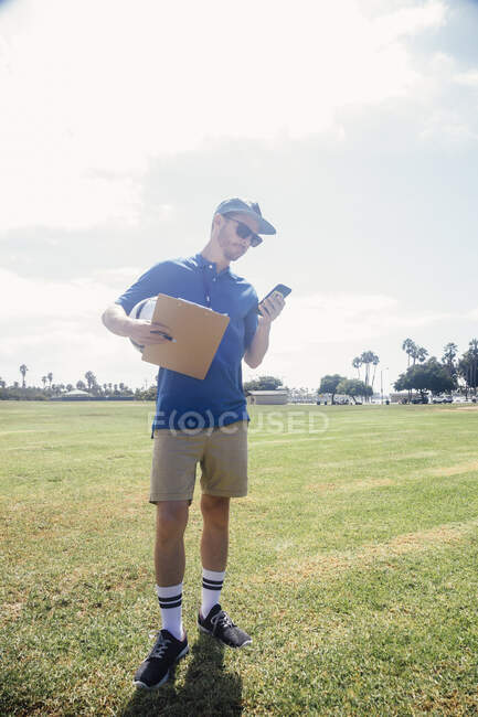 Male sports teacher with phone — Stock Photo