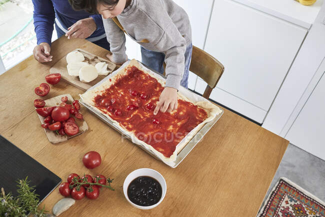 Nonna e nipote che fanno la pizza in cucina, vista elevata — Foto stock