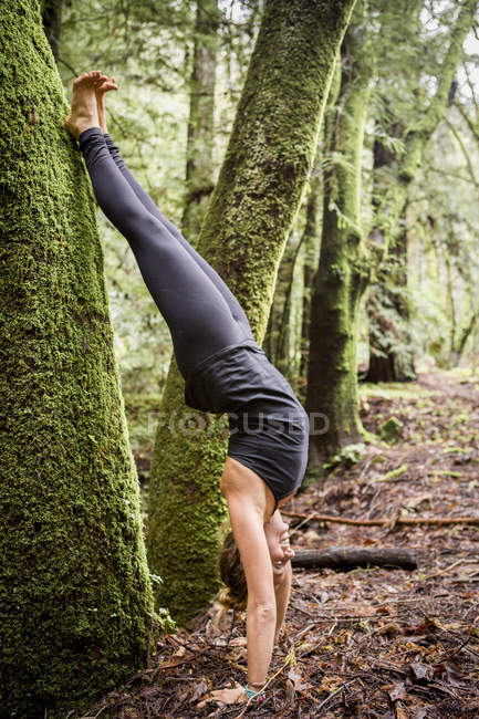 Young woman practicing yoga in forest — Stock Photo