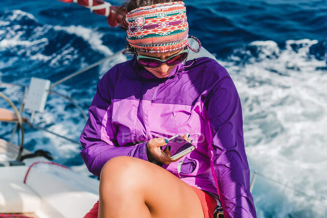 Young woman looking at smartphone aboard yacht, Croatia — Stock Photo