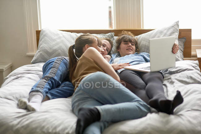 Amigos do sexo feminino usando laptop na cama — Fotografia de Stock