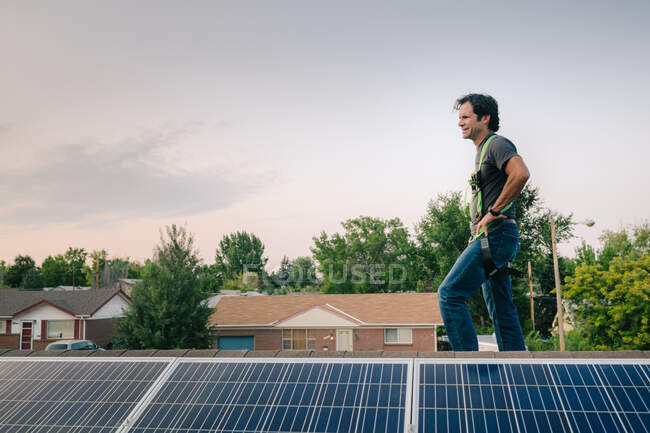 Trabajador de pie en el techo, la instalación de paneles solares - foto de stock