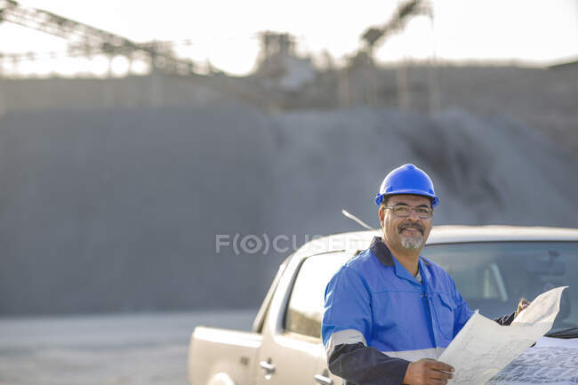 Porträt eines Steinbrucharbeiters im Steinbruch, der ein Dokument in der Hand hält — Stockfoto