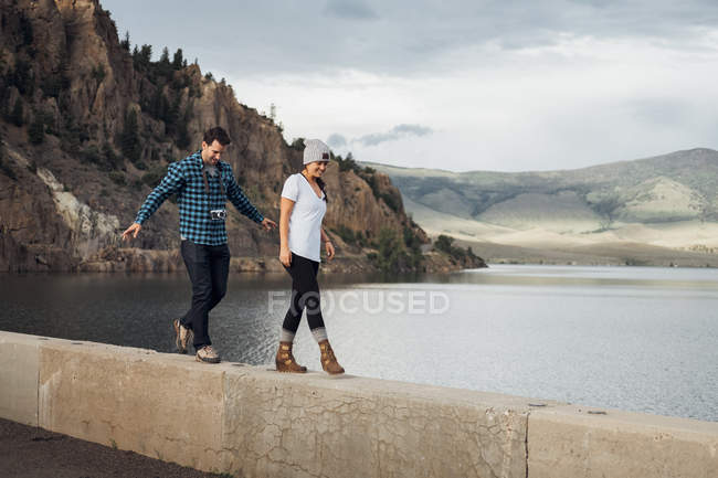 Couple marchant le long du mur à côté du réservoir Dillon, Silverthorne, Colorado, USA — Photo de stock