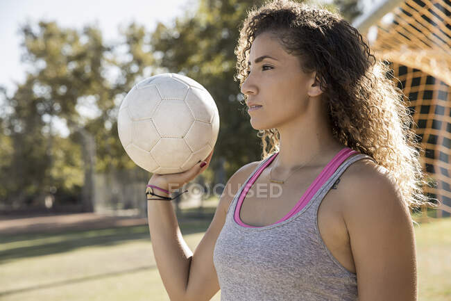 Портрет жінки, що тримає футбол, дивлячись — стокове фото