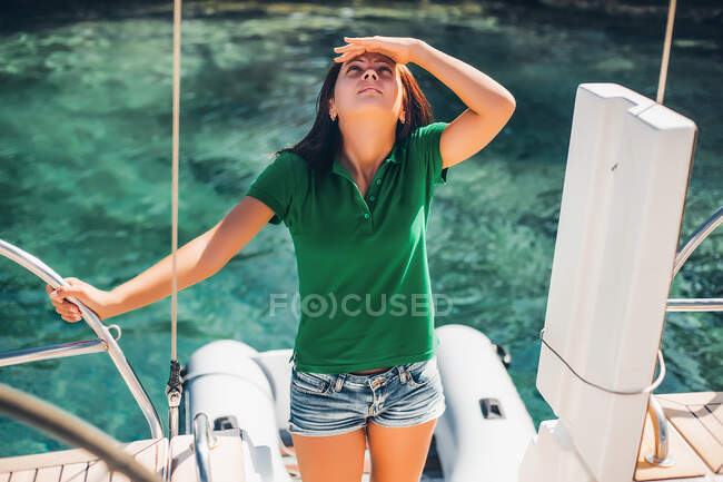 Woman on sailboat looking up at something — Stock Photo
