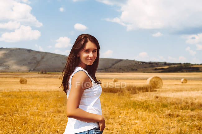 Портрет жінки в пшеничному полі, дивлячись на камеру — стокове фото