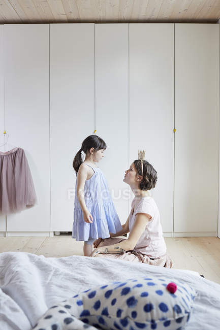 Мать и дочь на деревянном полу в современной спальне — стоковое фото