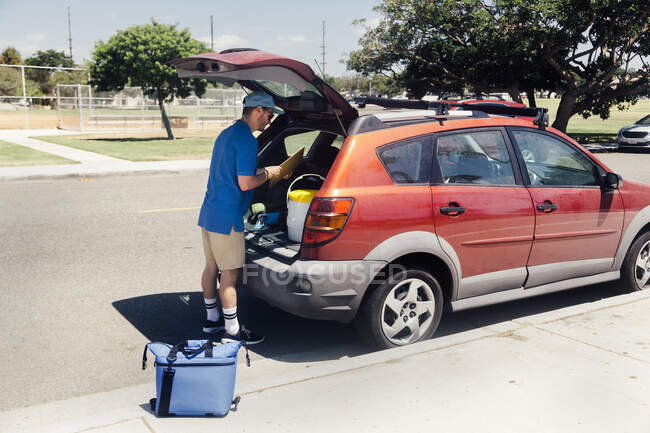 Male sport teacher packing car boot at school — Stock Photo