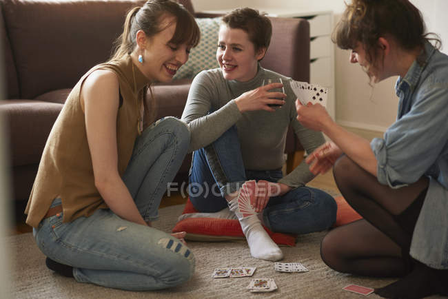 Amici che giocano a carte in salotto — Foto stock