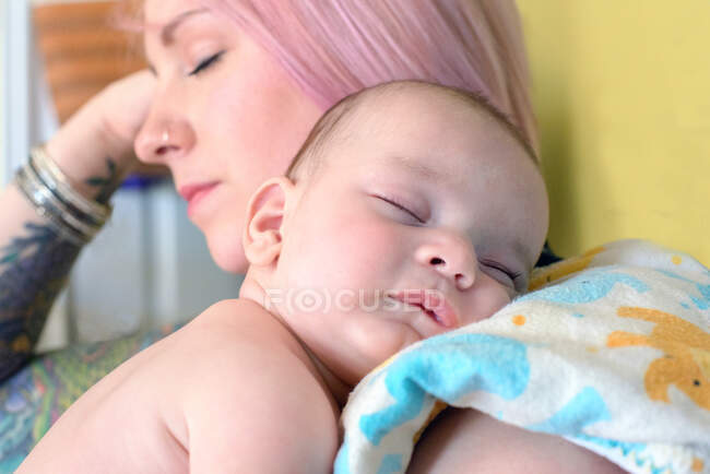 Woman asleep with sleeping baby boy on shoulder — Stock Photo