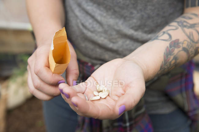 Vista ritagliata della donna che tiene i semi di anguria nella palma della mano — Foto stock