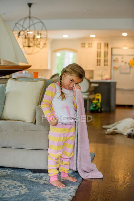 Menina com cobertor de conforto na sala de estar na hora de dormir, retrato — Fotografia de Stock