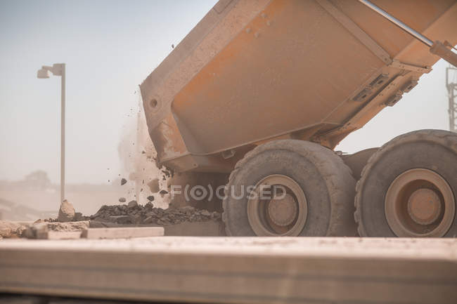 Dump truck in quarry, tipping load of stones — Stock Photo