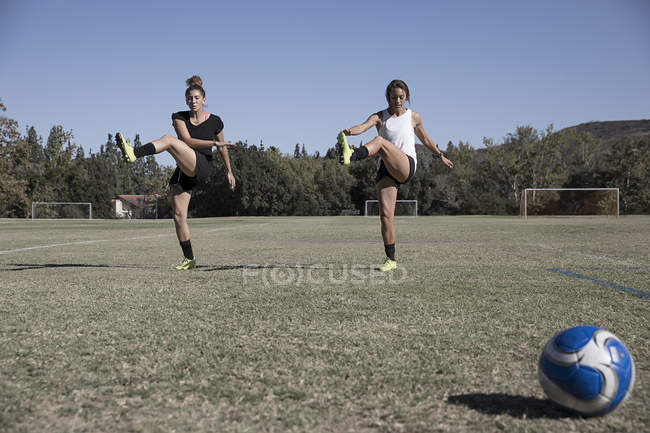 Mulheres que esticam as pernas no campo de futebol — Fotografia de Stock