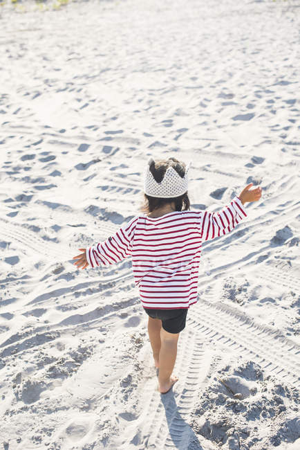 Vue arrière de la petite fille jouant sur la plage — Photo de stock