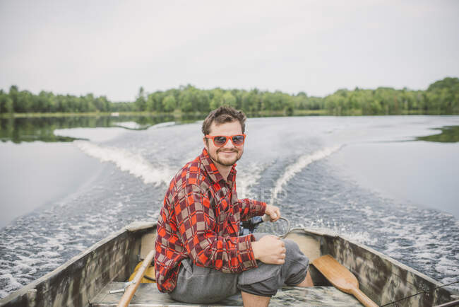 Портрет молодого человека в лодке на озере — стоковое фото